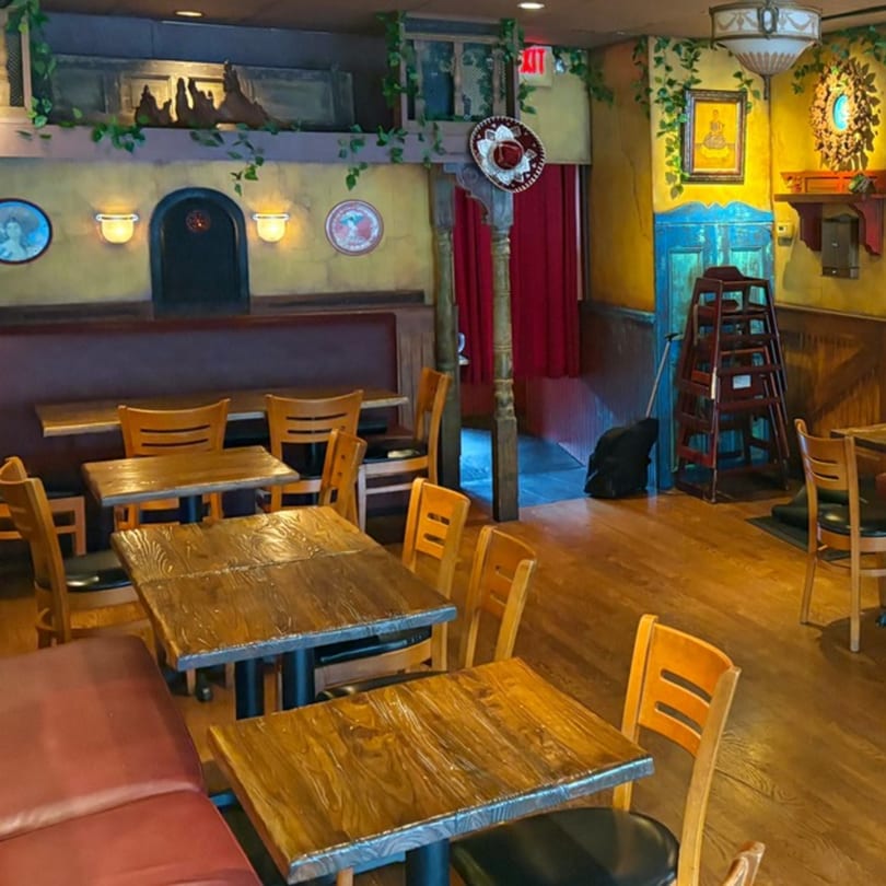 Tinga Fresh Mexican restaurant interior with wooden tables, red booths, and colorful Mexican-themed decor.